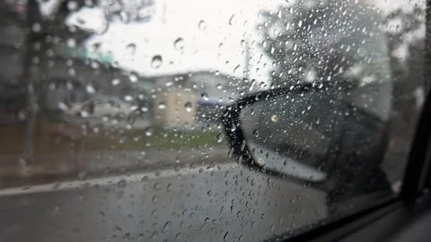 Rainy day car window close up with droplets on side mirror during drive Stockbeeldmateriaal 317929219