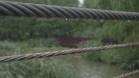 Rainy Day Close Up of Water Drops on Metal Bridge Cable Stock Footage 336630042