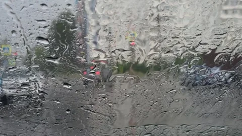 On a rainy day, I can see a heavy downpour in the parking lot through the windsh Stock Footage 314403400