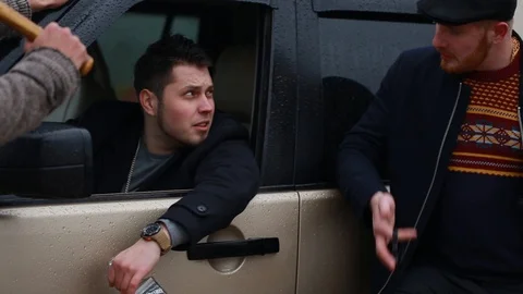Rainy day. Irishmans.Guy with a red beard is speaking to the guy sitting in jeep Stock Footage 128653492