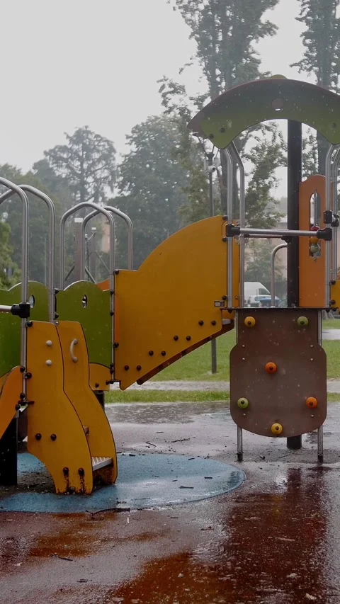 Rainy Day Playground Scene with Empty Colorful Equipment Stock Footage 310565173