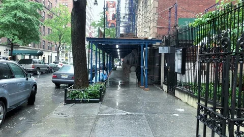 Rainy day raining man walking umbrella in rain under scaffolding Manhattan NYC 库存影片 108199201