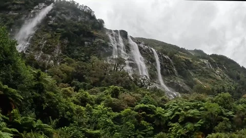 Rainy Day at Sandfly Point: Dramatic Waterfalls Cascading from Lush Cliffs .. Stock-Footage 295247495