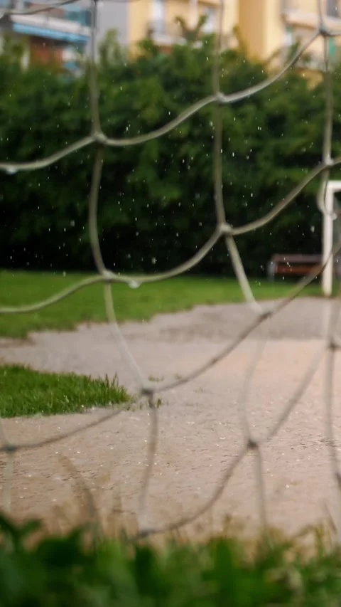 Rainy Day on the Soccer Field: View Through a Wet Goal Net Stock Footage 305774581