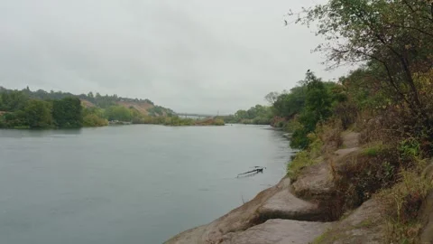 Rainy Day View of the American River near Hazel Bridge with Fisherman Stock Footage 320187625