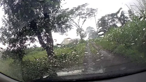 Rainy day view through car windshield on rural dirt road Stock Footage 279717485