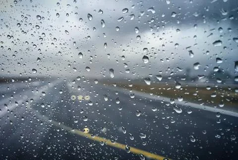 Rainy day view through a car window with raindrops Stock Photos