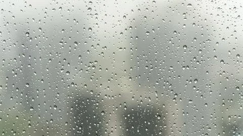 Rainy day view through a window with water droplets clinging to the glass Stock Photos