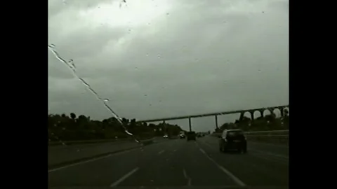 Rainy drive on highway through windshield VHS aesthetic Stock Footage 330261957