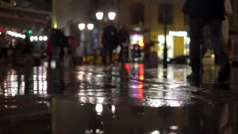 Rainy evening, raindrops fall on colorful asphalt illuminated by street lamps Stock Footage 77967298