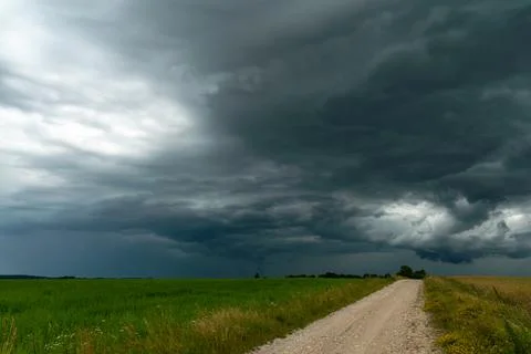 A rainy gray cloud hovered over the field. A hurricane over an agricultural f Foto stock