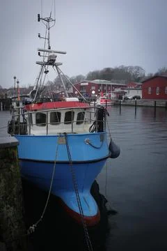 Rainy harbor scene in Eckernfrde, Germany, featuring small fishing boats mo.. Stock Photos