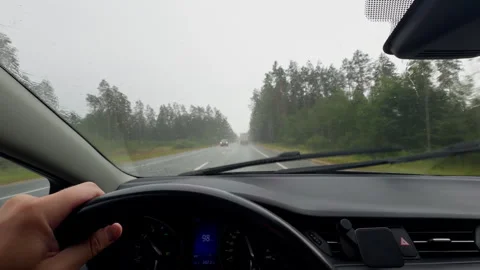 Rainy highway drive from car interior with windshield wipers, steering wheel Stock Footage 345452414