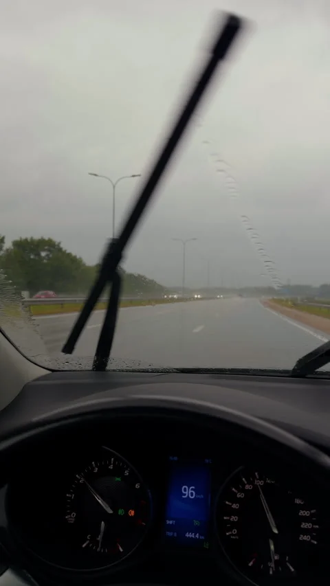 Rainy highway driving view from car interior with windshield wipers, wet road Stock Footage 345530371