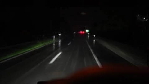 Rainy highway night drive through blurred windshield glowing lights reflections  Stock Footage 310485754