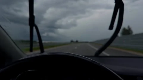 Rainy highway view through car windshield with moving wipers under dark storm Stock Footage 345452549