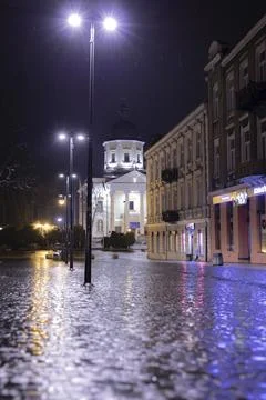 Rainy Night in the Old Town Square. Old cobblestone street and church Stock Photos