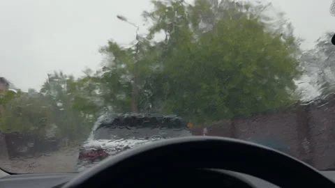 Rainy road view through wet windshield from car interior with SUV ahead under Stock Footage 345532902