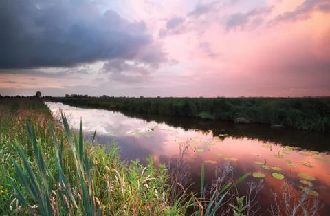 Rainy sunset over river Stock Photos