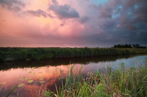 Rainy sunset on river Stock Photos