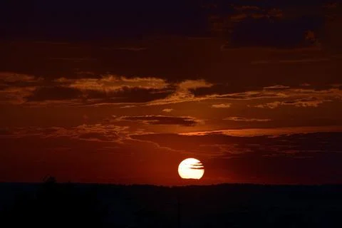 A rainy sunset, the summer sun sets in the clouds. Stock Photos