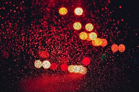 Rainy traffic bokeh seen through wet car window Foto stock