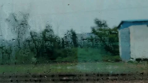 Rainy Train Window View of Green Countryside in Motion. 動画素材 347931986