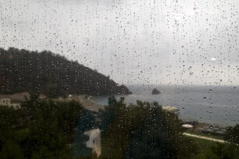 Rainy view on the beach through the window Stock Photos