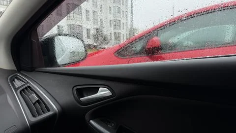 Rainy view from the driver or passenger seat of a car, featuring the dark Stock Photos