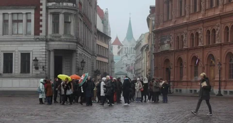 Rainy walking tour in Riga Old Town square with church in mist Stock Footage 321046922