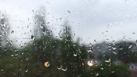 Rainy weather behind a wet window. Large drops of water flow down the glass Stock Footage 195412873