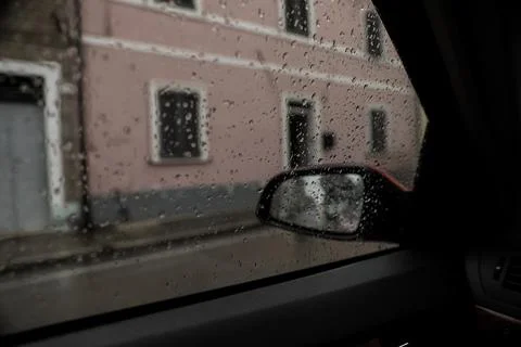 Rainy weather in city, view through car window covered with drops Stock Photos