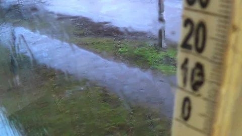 Rainy weather outside. Drops on the window glass, foggy thermometer scale Stock-Footage 125517755