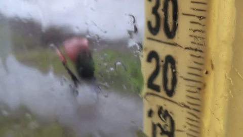 Rainy weather outside. Drops on the window glass, foggy thermometer scale Stock Footage 126122034