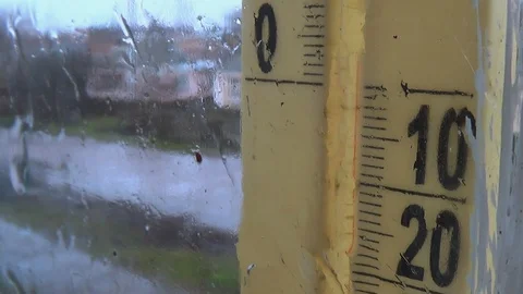 Rainy weather outside. Drops on the window glass, foggy thermometer scale Stock-Footage 127088476