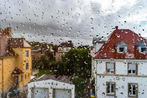 Rainy weather view through the window with water drops on the glass Stock Photos
