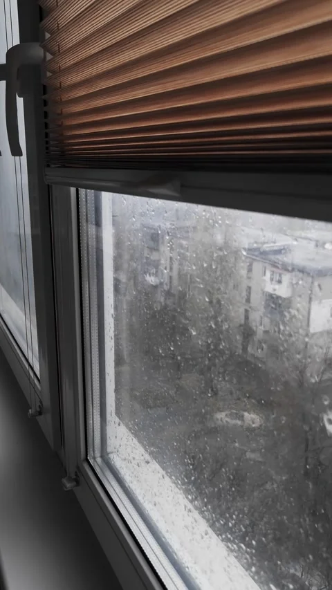 Rainy Window with Copper Blinds Overlooking a Grey City Stock Footage 325223502