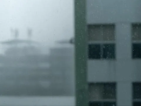 Rainy Window View of Distant Buildings Through Falling Raindrops, Moody Urb.. Stock Photos