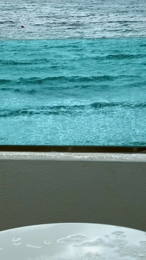 Rainy window view overlooking the sea waves Video stock 318092584