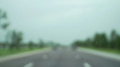 Rainy windshield driving down highway raindrops Stock Footage 84561934