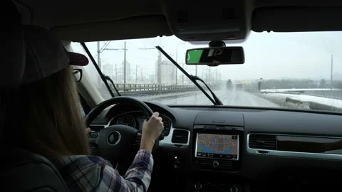 Rainy winter. Wipers work. Outside, everything is gray. The girl is driving a Stock-Footage 103582184