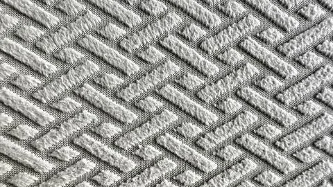 Raised diamond lattice pattern gray textural fabric knit textile background.. Stock Photos