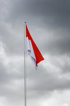 Raised flag of Indonesia. Cloud background. Stock Photos