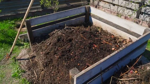 Raised garden bed filled with dark compost soil in spring Vídeos de archivo 341747974
