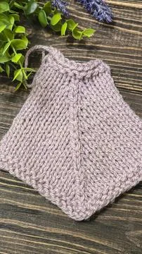 A raised openwork pattern knitted with colored yarn on a wooden background. Foto stock