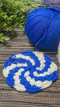 A raised openwork pattern knitted with colored yarn on a wooden background. Foto stock