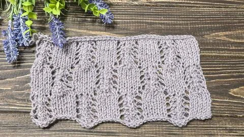 A raised openwork pattern knitted with colored yarn on a wooden background. Foto stock