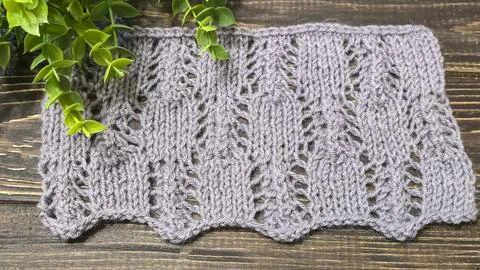 A raised openwork pattern knitted with colored yarn on a wooden background. Foto stock