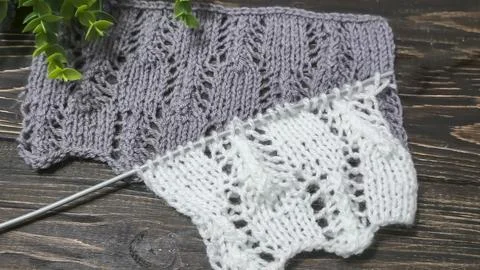 A raised openwork pattern knitted with colored yarn on a wooden background. Foto stock