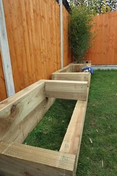 Raised vegetable, flower bed, made with Railway sleepers. Bamboo screening Stock Photos